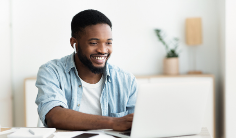 Smiling African American man in earphones studying foreign language online